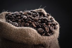 Green coffee beans in a jute sack at the works